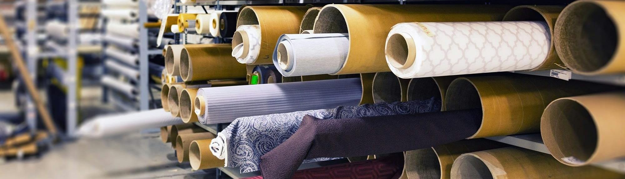 Rows of textile rolls stored in a factory for industrial manufacturing.